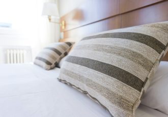 A close-up of a neatly made bed with pillows, representing hotel accommodations covered by Solara Mental Health’s travel benefit for veterans.