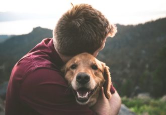 A veteran hugging his happy dog outdoors, symbolizing the strong bond and emotional support provided by service animals in the healing process at Solara Mental Health.