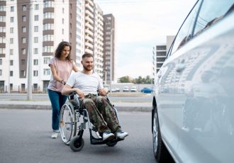 Veteran in Wheelchair Being Assisted to Car