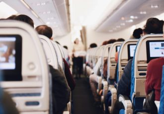 View from inside an airplane cabin with passengers seated, representing the veterans traveling to Solara with all travel costs covered.