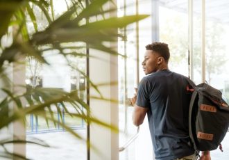 A young man with a backpack heading out the door, signifying the beginning of his journey to mental health recovery.